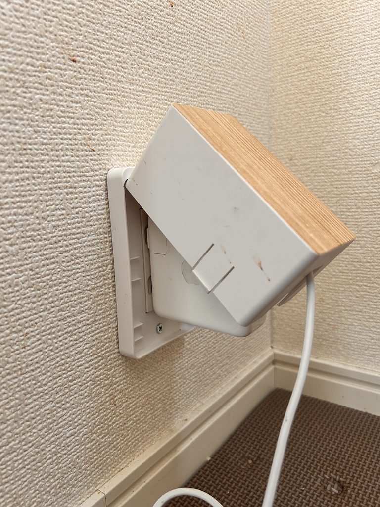 大型ACアダプターを挿したためカバーが閉まらない状態のコンセントガード