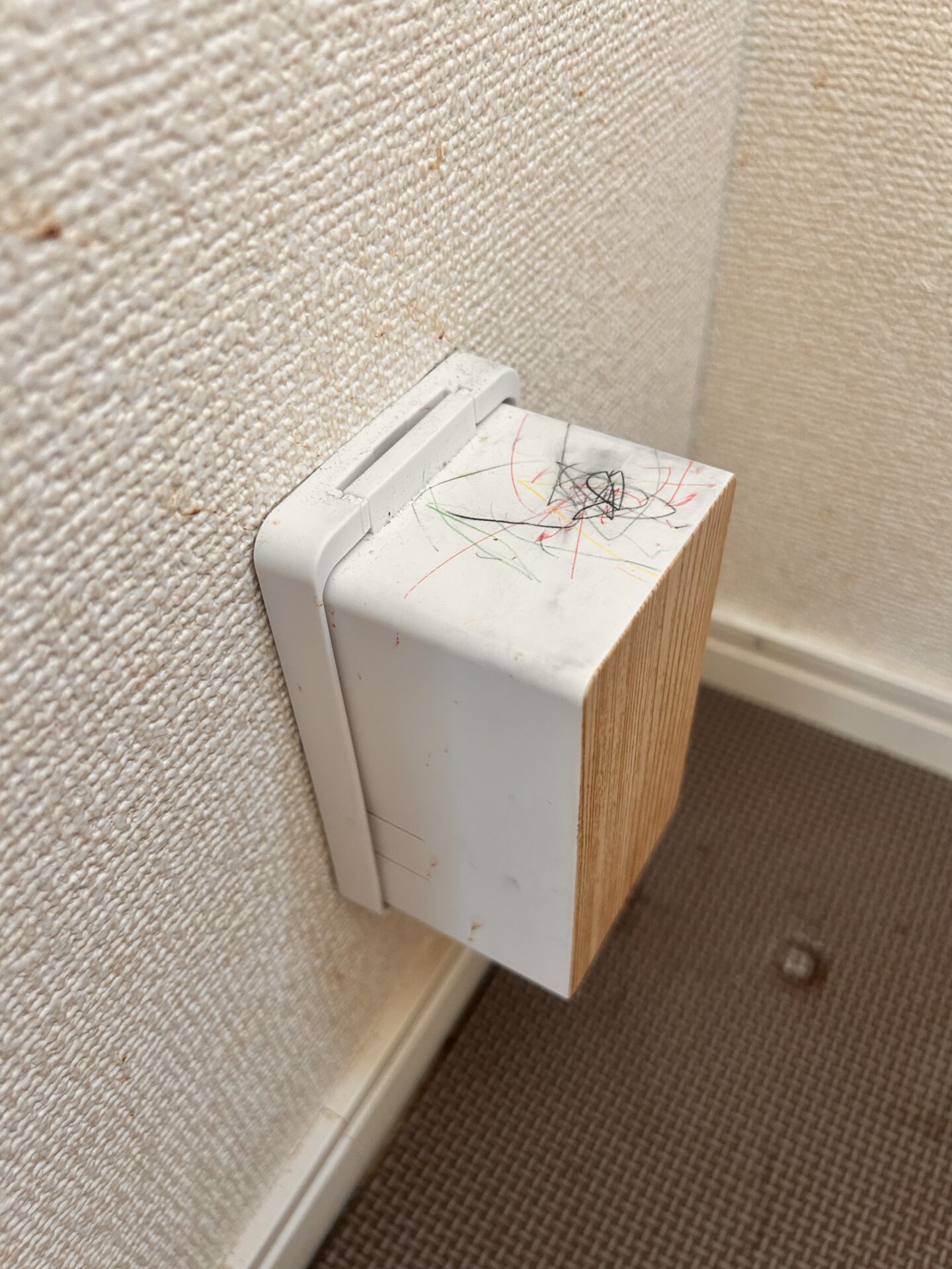 子どもにクレヨンや色鉛筆で落書きされたコンセントガードの実物
