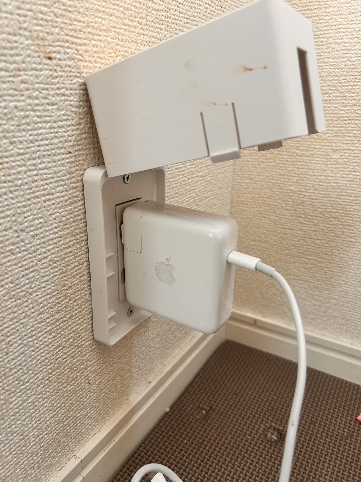 MacBookの充電器を挿すとコンセントガードのカバーが閉まらない様子