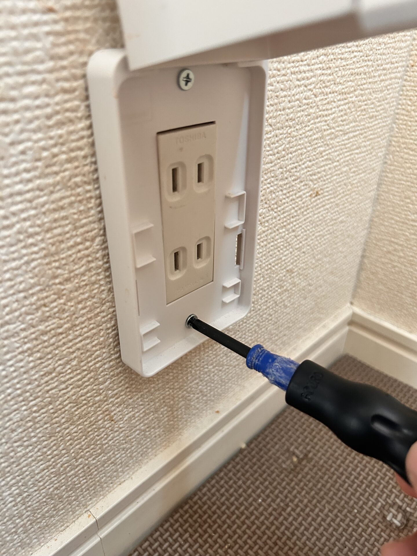 プラスドライバーでネジを締めて取り付けている作業風景