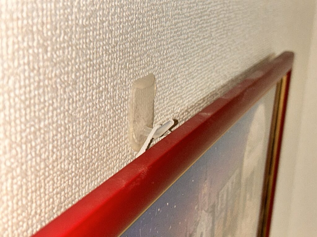 額縁の紐がダイソー壁掛けフックに掛かっている状態